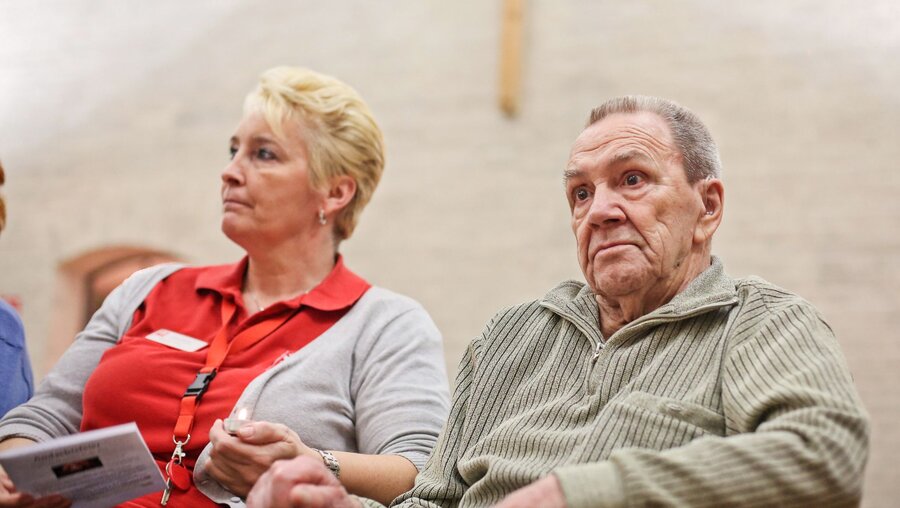 Ein älterer Mann mit einer Begleitperson bei einer Andachtsfeier für alternde Menschen mit Demenz / © Markus Nowak (KNA)
