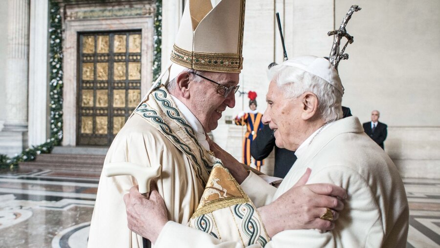 Papst Franziskus (l.) umarmt den emeritierten Papst Benedikt XVI. am 8. Dezember 2015 im Vatikan / © Cristian Gennari/Romano Siciliani (KNA)