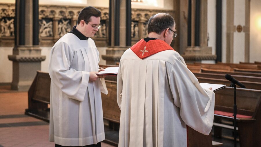 Ein Seminarist (l.) und ein Priester in einer Kirche / © Julia Steinbrecht (KNA)