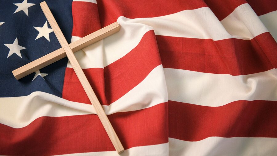 Kreuz und US-Flagge / © Julia Steinbrecht (KNA)