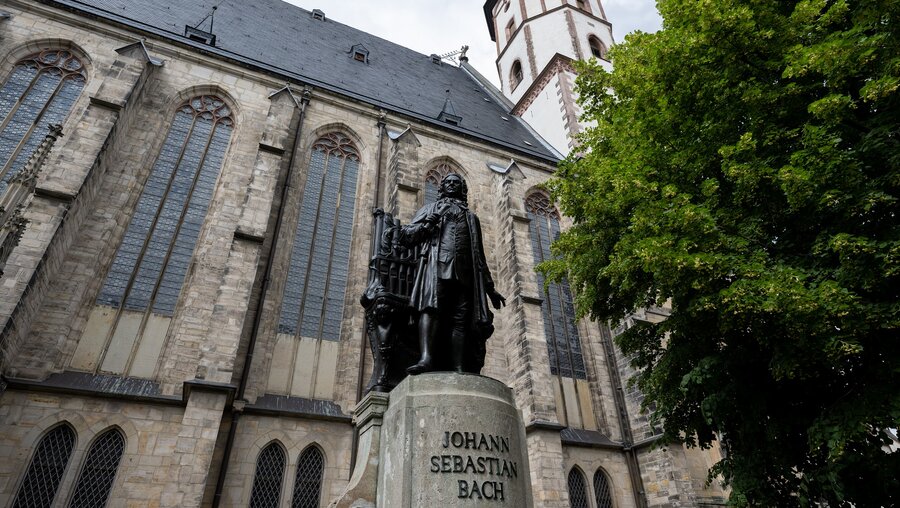 Ein Denkmal erinnert vor der Thomaskirche in Leipzig an den Komponisten Johann Sebastian Bach. / © Hendrik Schmidt (dpa)