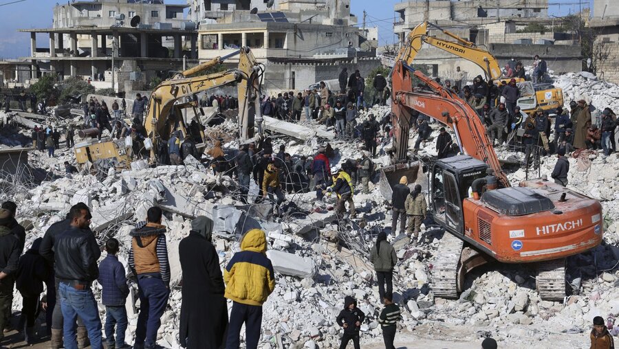 Rettungskräfte und Anwohner durchsuchen die Trümmer eingestürzter Gebäude nach Überlebenden / © Ghaith Alsayed/AP (dpa)