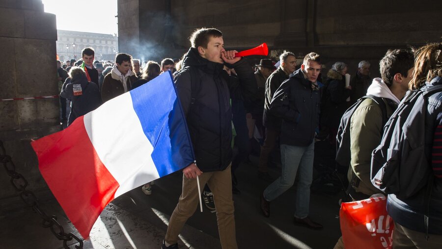 Ein junger Mann mit der Flagge Frankreichs / © Corinne Simon (KNA)