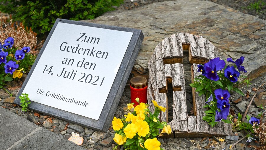 Ein von freiwilligen Helfern gestifteter Gedenkstein vor der Kirche in Dernau ist mit Blumen geschmückt am 13. Juni 2022 / © Harald Oppitz (KNA)