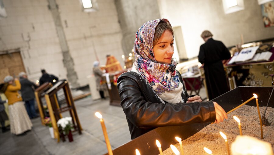 Eine orthodoxe Christin zündet eine Kerze an / © Fabian Sommer (KNA)