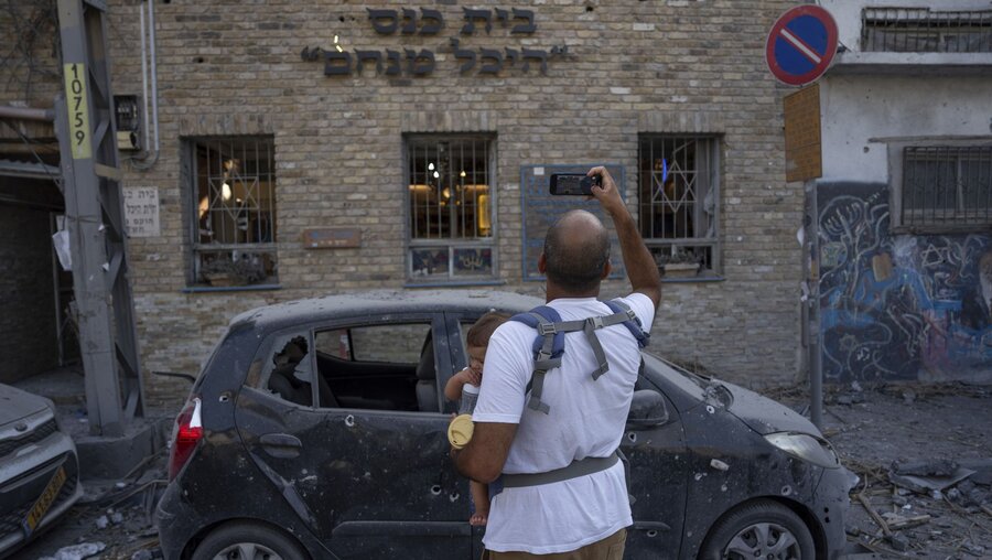 Tel Aviv: Israelis inspizieren die Trümmer eines Gebäudes, einen Tag nachdem es von einer aus dem Gazastreifen abgefeuerten Rakete getroffen wurde / © Oded Balilty/AP (dpa)