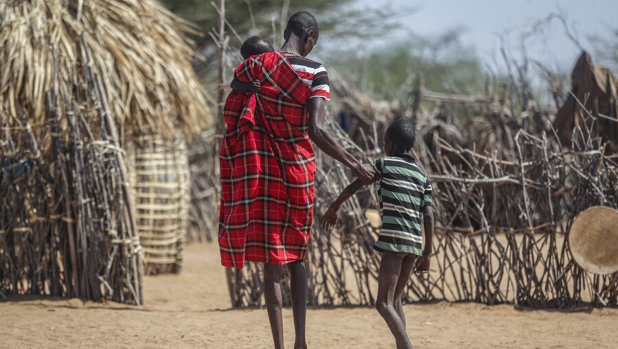 Ein Vater hilft seinem unterernährten Sohn beim Gehen in der Nähe ihrer Hütte in dem Dorf Lomoputh im Norden Kenias / © Brian Inganga/AP (dpa)
