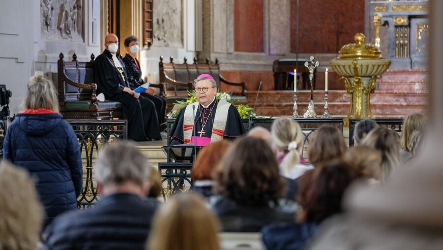 Bischof Franz-Josef Bode (m.) spricht im Gottesdienst / © Jens Schulze (dpa)