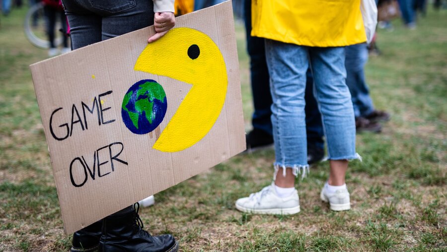 "Game Over" steht beim globalen Klimastreik der Klimaschutzbewegung Fridays for Future auf dem Plakat einer Teilnehmerin geschrieben / © Christoph Schmidt (dpa)