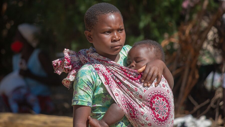 Eine junge Frau trägt ihr Kind in einem Tuch / © ivanbrunom (shutterstock)