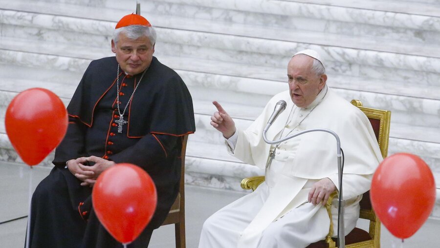 Papst Franziskus (r) sitzt neben Kardinal Konrad Krajewski / © Fabio Frustaci (dpa)
