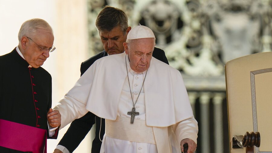 Papst Franziskus mit Gehstock hält sich an seinem Adjutanten, Monsignore Leonardo Sapienza (l), fest / © Alessandra Tarantino/AP (dpa)