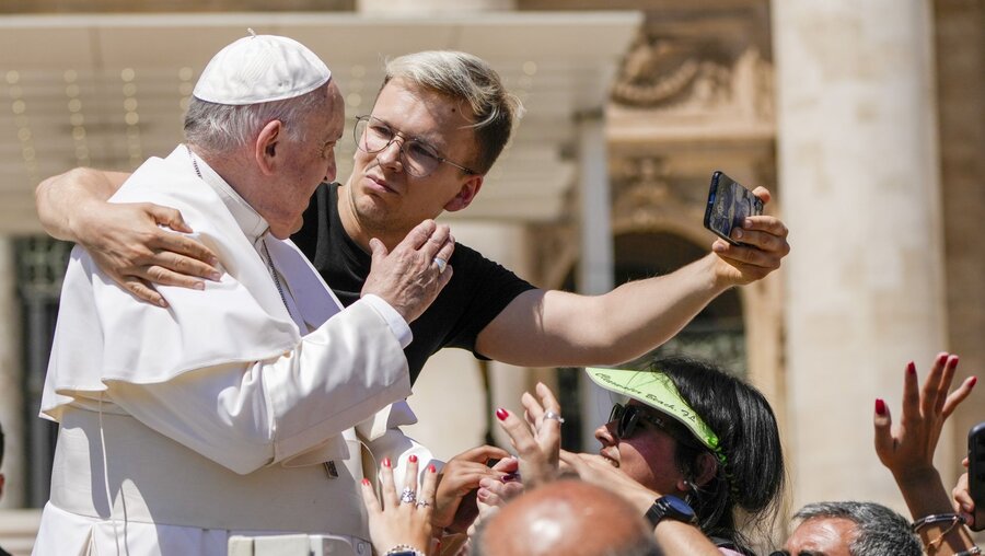 Ein junger Mann und der Papst machen im Papamobil ein Selfie / © Alessandra Tarantino (dpa)