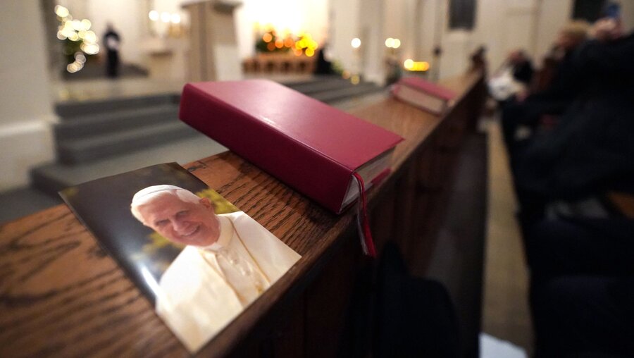 Ein Bild von Papst Benedikt neben einem Gotteslob / © Marcus Brandt (dpa)