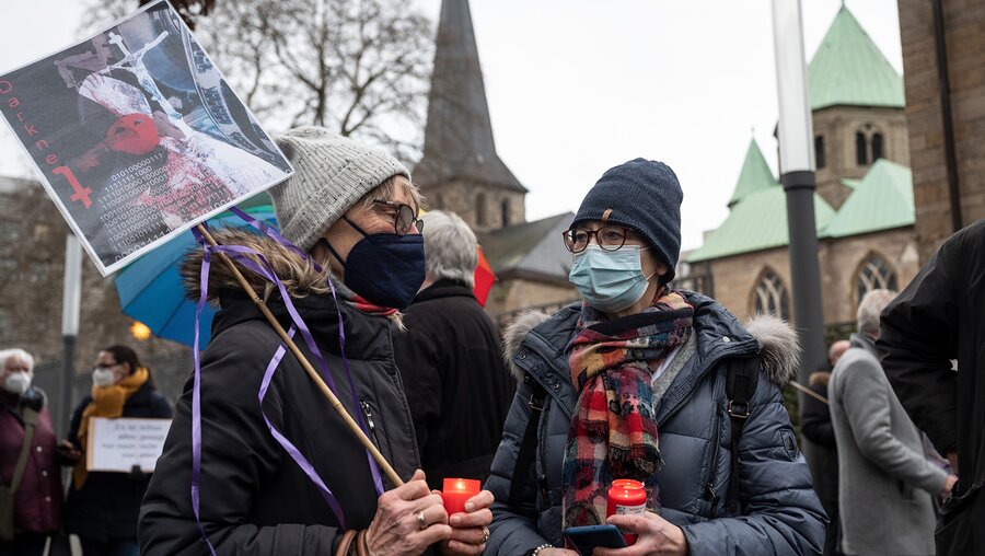 Zwei Frauen beteiligen sich vor dem Essener Dom an einer Solidaritätsaktion für Betroffene sexuellen Missbrauchs durch Geistliche. / © Bernd Thissen (dpa)