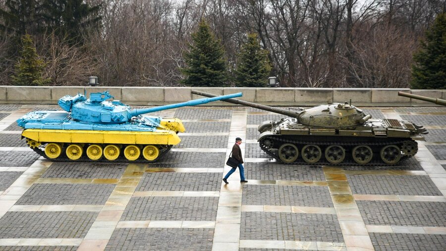 Ukraine, Kiew: Ein Mann geht an zwei Panzern vorbei die nahe der Mutter-Heimat-Statue stehen / © Madeleine Kelly (dpa)