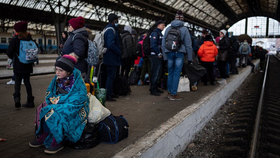 Flüchtende warten am Bahnsteig des Bahnhofs in Lwiw in der Ukraine. / © Bernat Armangue/AP (dpa)