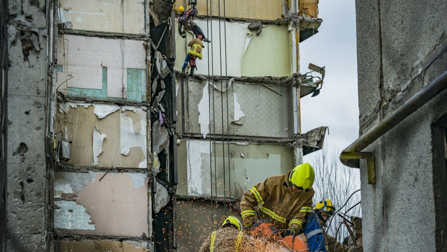 Rettungskräfte arbeiten am zwischen den Trümmern eines durch Beschuss zerstörten Gebäudes, nach Abzug russischer Truppen. / © Celestino Arce Lavin/ZUMA Press Wire (dpa)