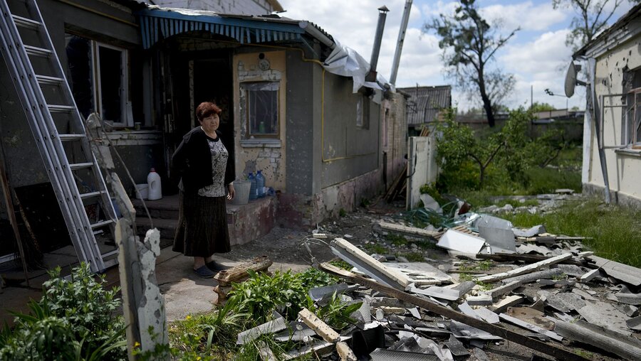 Ukraine, Irpin: Eine Frau steht vor ihrem durch Angriffe zerstörten Haus / © Natacha Pisarenko (dpa)