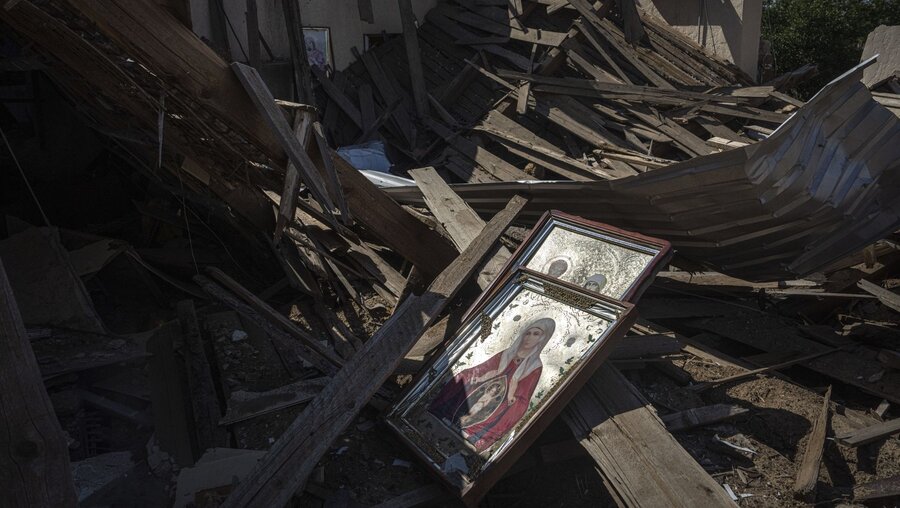 Ikonen liegen auf den Trümmern einer Kirche, die nach einem russischen Angriff an der Frontlinie zerstört wurde / © Evgeniy Maloletka/AP (dpa)