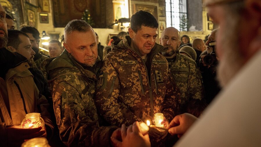 Ukrainische Soldaten erhalten von einem Priester das Friedenslicht von Bethlehem / © Evgeniy Maloletka (dpa)