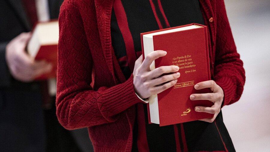 Eine Frau hält eine Bibel bei einem Gottesdienst zur Beauftragung von Frauen und Männern zum Dienst des Lektors und Katecheten im Petersdom im Vatikan am 23. Januar 2022. / © Cristian Gennari/Romano Siciliani (KNA)