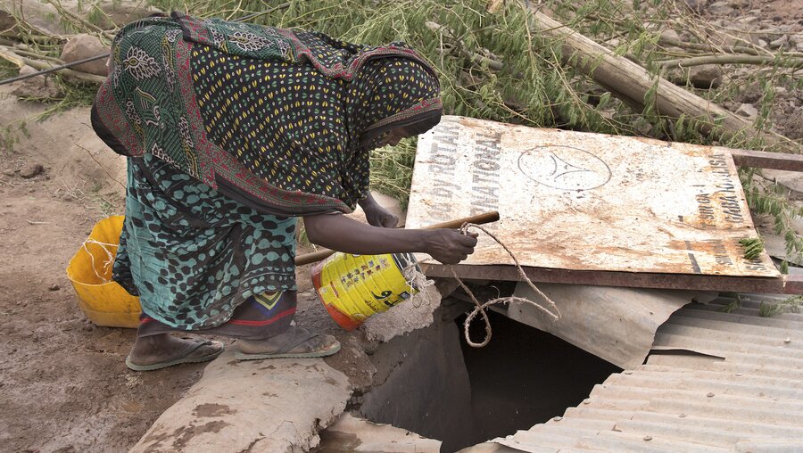 Eine Äthiopierin schöpft Wasser aus einer Zisterne / © Bettina Ruehl (epd)