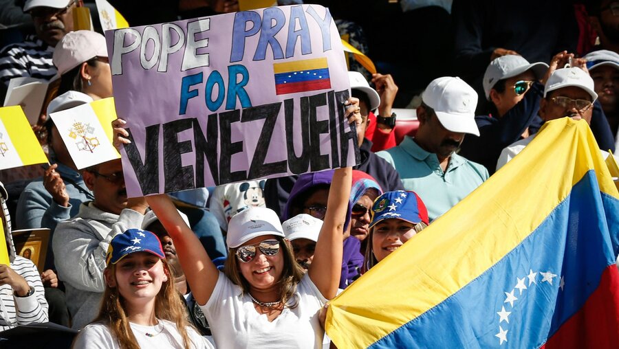 Eine junge Frau hält ein Schild mit der Aufschrift "Pope pray for Venezuela" / © Paul Haring (KNA)