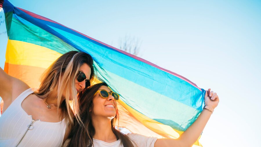 Symbolbild Homosexuelles Paar mit Regenbogenfahne / © Jose Luis Carrascosa (shutterstock)