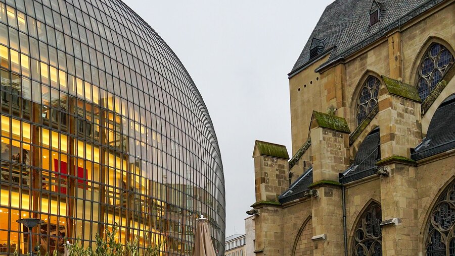 Evangelische Antoniterkirche in der Kölner Innenstadt neben modernem Design eines Modehauses / © Wirestock Creators (shutterstock)