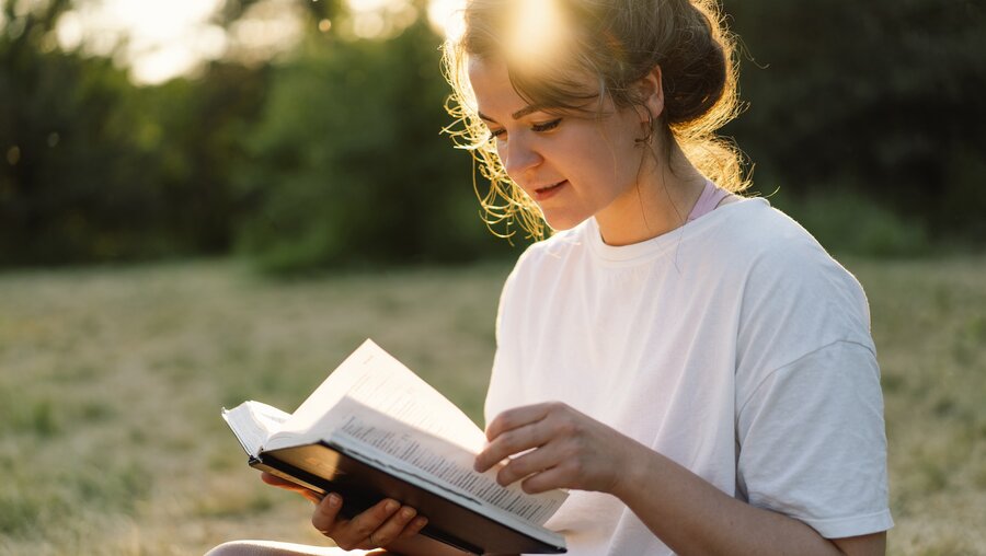 Christliche Frau hält Bibel in den Händen. / © Nastyaofly (shutterstock)