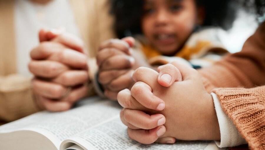 Kinder beten und lesen in einer Bibel / © PeopleImages.com - Yuri A (shutterstock)