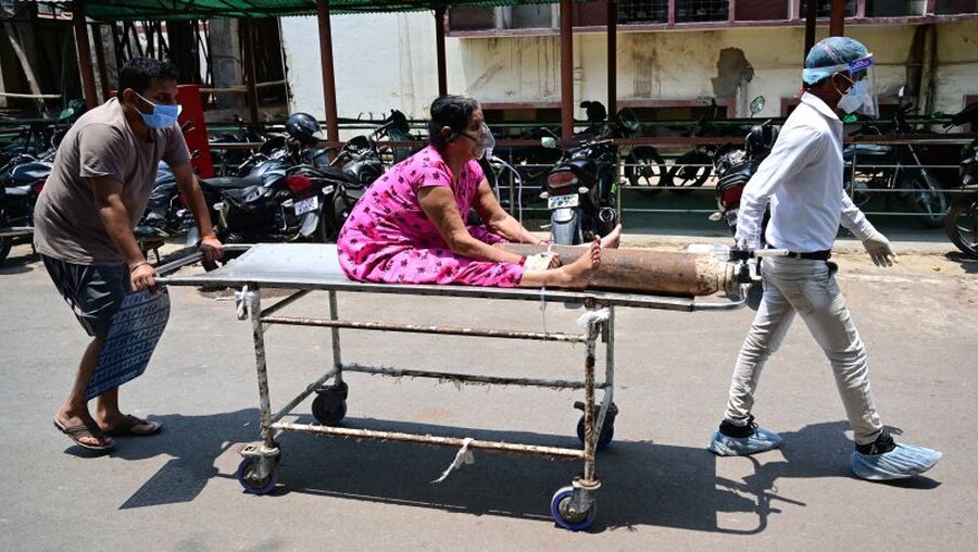 Indien: Eine Frau sitzt mit einer Sauerstoffflasche auf einer Trage / © Prabhat Kumar Verma (dpa)