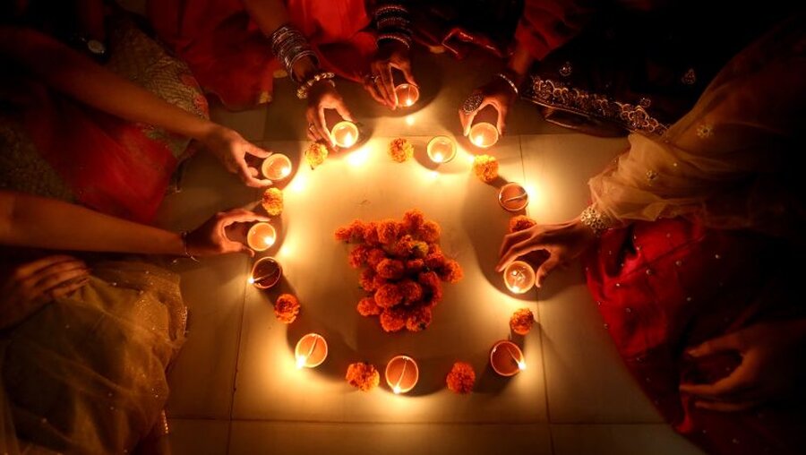 Indische Frauen zünden anlässlich des Lichterfestes Diwali Öllampen an / © Str./XinHua (dpa)