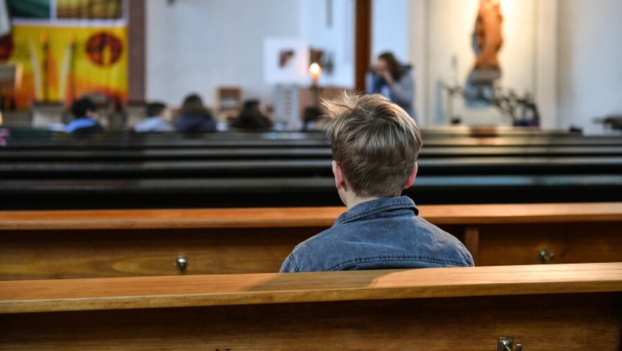 Junge auf einer Kirchenbank / © Harald Oppitz (KNA)