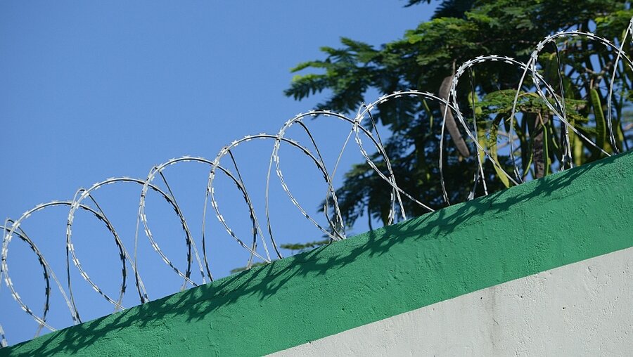 Stacheldraht über einer Gefängnismauer (KNA)