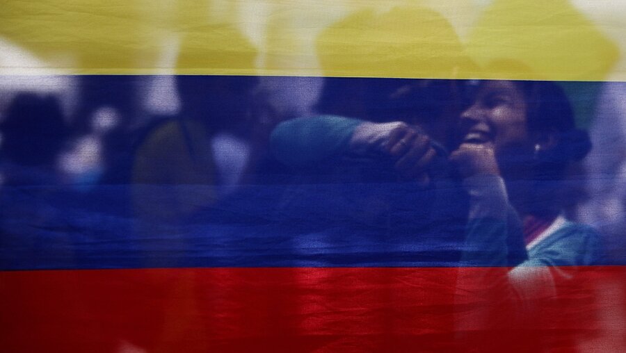 Ein Paar hinter einer Flagge bei einem Friedensmarsch in Cali, Kolumbien, am 9.4.15 (dpa)