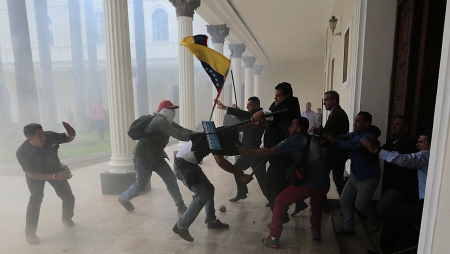 Zusammenstöße zwischen vermutlichen Regierungsanhängern und Abgeordneten im Parlament in Caracas  / © Fernando Llano (dpa)