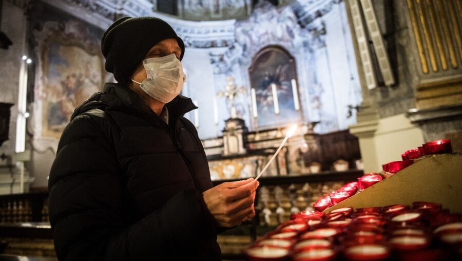 Mann mit Mundschutz in einer Kirche / © Alessandro Crinari (dpa)