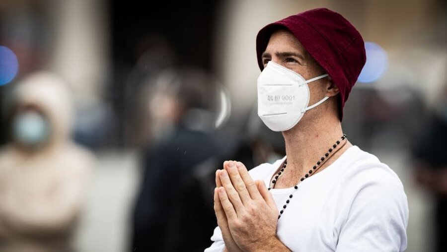 Mann mit Mundschutz im Gebet / © Cristian Gennari/Romano Siciliani (KNA)