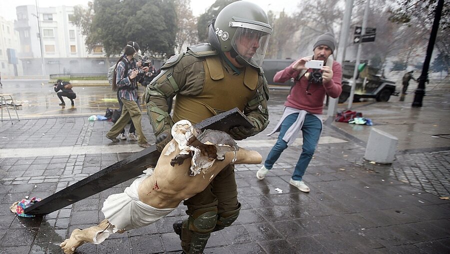 Demonstranten in Chile stehlen Christus-Figur und zerstören es auf offener Straße. / © Mario Ruiz (dpa)