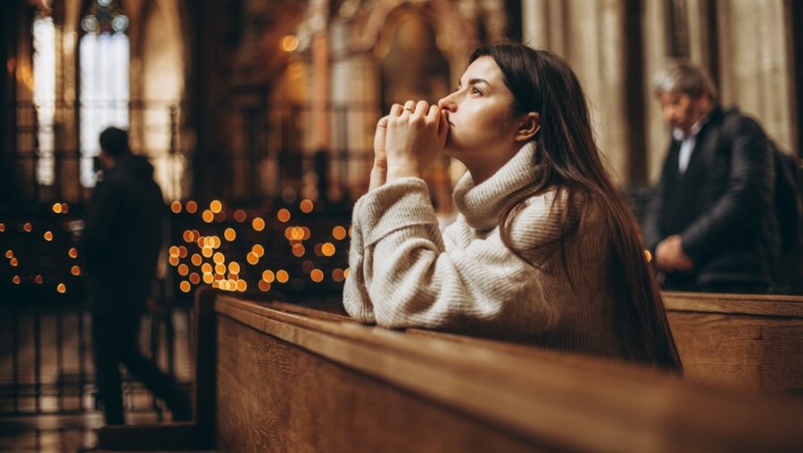 Menschen beten in einer Kirche / © Anna Nass (shutterstock)