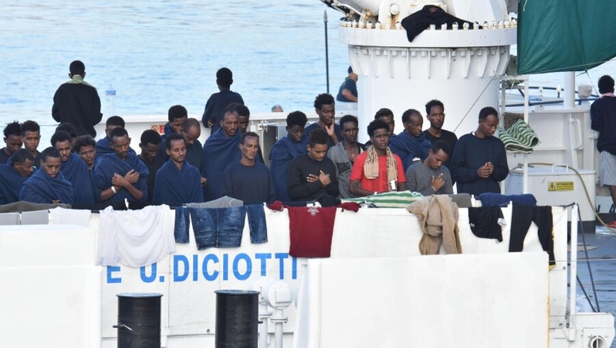 Migranten beten an Bord des italienischen Küstenwachschiffes "Diciotti" im Hafen von Catania / © Orietta Scardino (dpa)