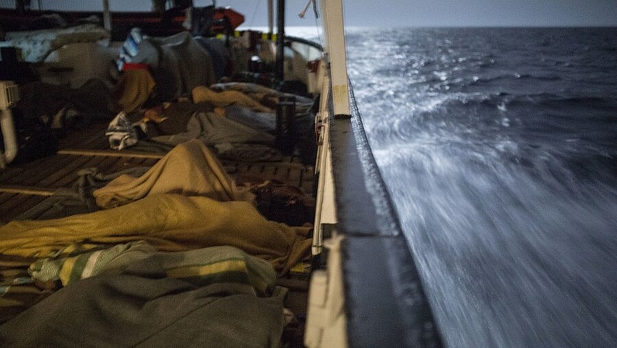 Migranten schlafen an Bord des Rettungsschiffs / © Olmo Calvo (KNA)