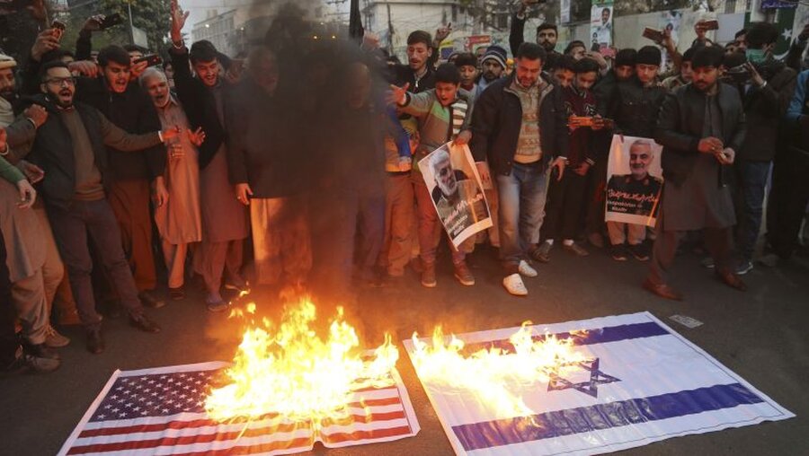 Muslime in Pakistan verbrennen aus Protest gegen den Luftangriff die Flaggen der USA und Israels / © K.M. Chaudary/AP/dpa (dpa)