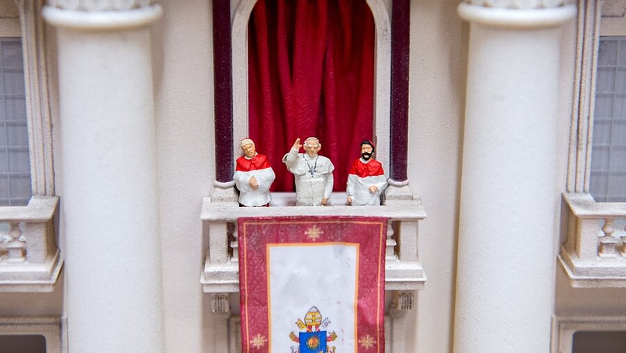 Eine winzige Papst-Figur winkt in einer Werkstatt des "Miniatur Wunderlandes" / © Daniel Reinhardt (dpa)