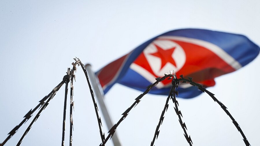 Nordkoreanische Flagge hinter Stacheldraht / © Vincent Thian (dpa)