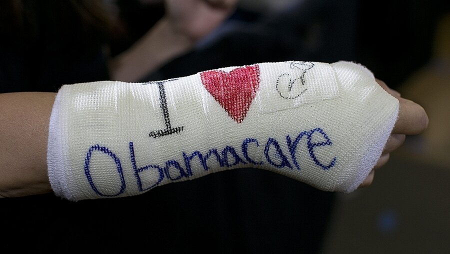 Eine Unterstützerin von "Obama-Care" / © Yoon S. Byun / Pool (dpa)