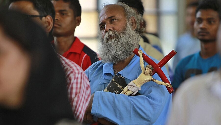 Ein Mann mit Kreuz in einem Gottesdienst (Archiv) / © Channi Anand (dpa)