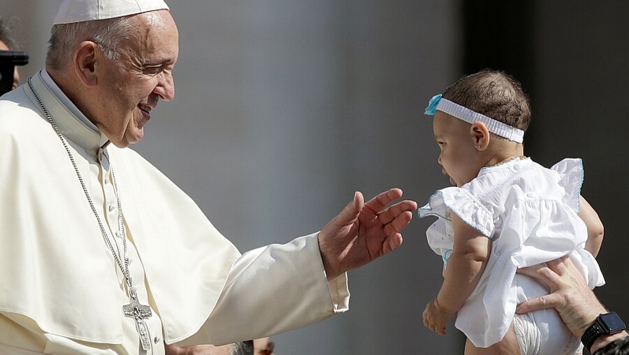 Papst Franziskus begrüßt bei der wöchentlichen Generalaudienz auf dem Petersplatz ein Baby / ©  Alessandra Tarantino (dpa)